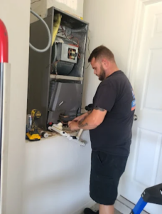 HVAC professional inspecting the outdoor electrical control panel to diagnose and repair a residential heating and cooling system